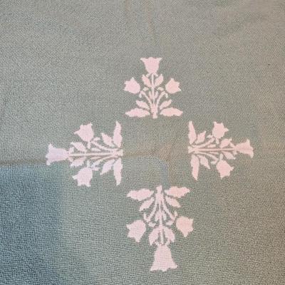 handmade green and white crochet blanket with a leaves pattern and fringed edges with a knitted reverse cat themed throw