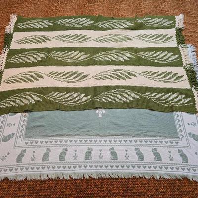handmade green and white crochet blanket with a leaves pattern and fringed edges with a knitted reverse cat themed throw