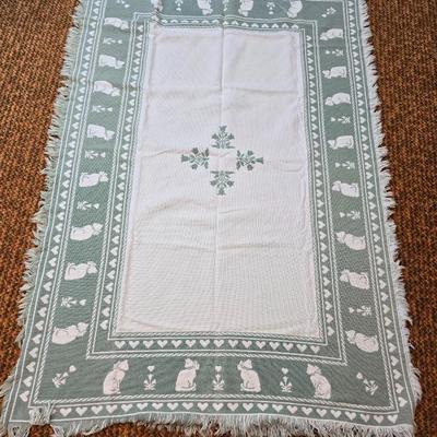 handmade green and white crochet blanket with a leaves pattern and fringed edges with a knitted reverse cat themed throw