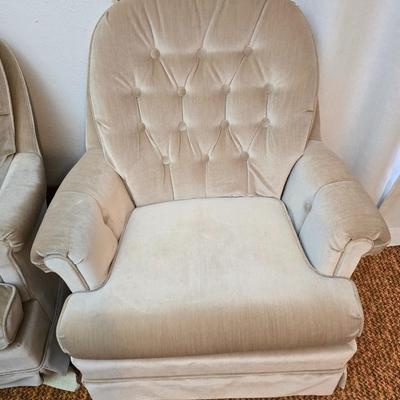 Pair of Best Chairs Inc. upholstered swivel rocker chairs with tufted backs and skirted bases.