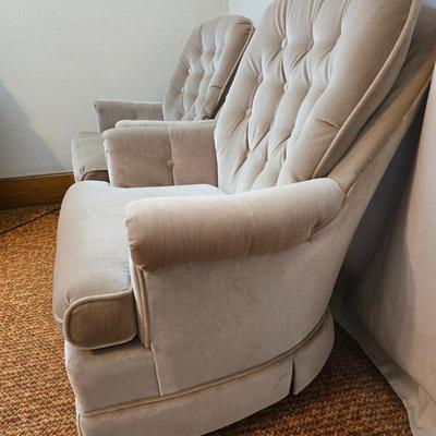 Pair of Best Chairs Inc. upholstered swivel rocker chairs with tufted backs and skirted bases.