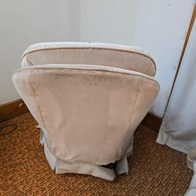 Pair of Best Chairs Inc. upholstered swivel rocker chairs with tufted backs and skirted bases.