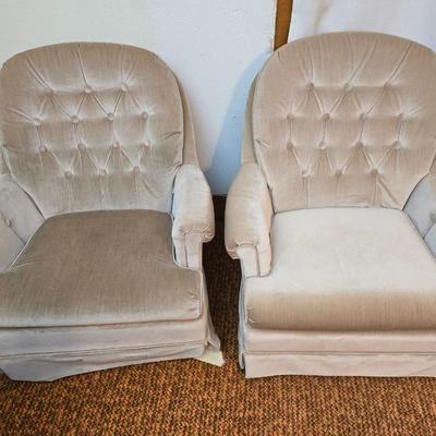 Pair of Best Chairs Inc. upholstered swivel rocker chairs with tufted backs and skirted bases.