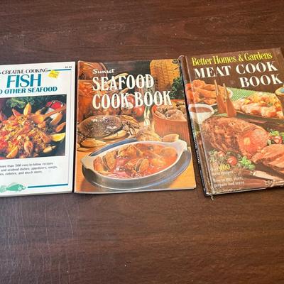 Sale Photo Thumbnail #93: Includes Creative Cooking: Fish and Other Seafood (1980s softcover), Sunset Seafood Cookbook (vintage edition with color photos), and Better Homes & Gardens Meat Cook Book (1960s hardcover, over 400 recipes). Classic mid-century cooking guides featuring m