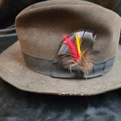 Bronzine felt Stetson Sutley fedora hat with a black grosgrain ribbon and feather accent. Size 7 1/4