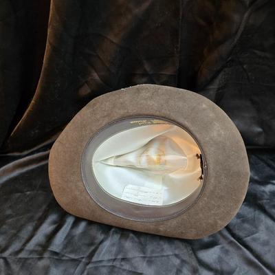 Bronzine felt Stetson Sutley fedora hat with a black grosgrain ribbon and feather accent. Size 7 1/4