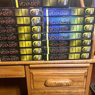 Sale Photo Thumbnail #106: Extensive Star Trek: Voyager VHS lot featuring early season episodes released by Paramount Home Video. Includes 22 tapes with two episodes per volume, covering key storylines such as Caretaker, Eye of the Needle, Learning Curve, Projections, Cold Fire, an