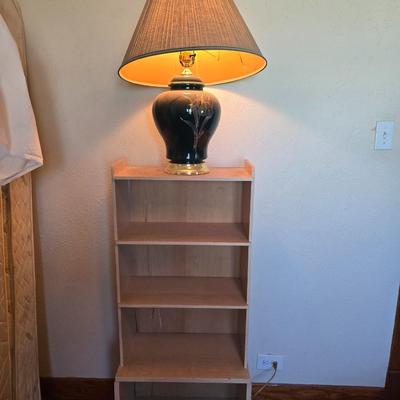 Small natural wood shelf with large ceramic lamp with an iris on it