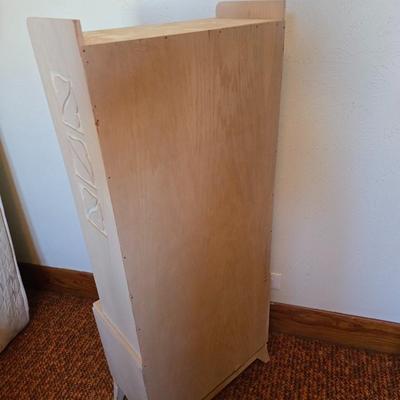 Small natural wood shelf with large ceramic lamp with an iris on it