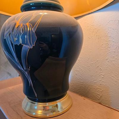 Small natural wood shelf with large ceramic lamp with an iris on it