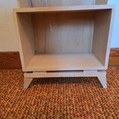 Small natural wood shelf with large ceramic lamp with an iris on it