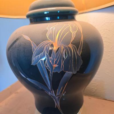 Small natural wood shelf with large ceramic lamp with an iris on it