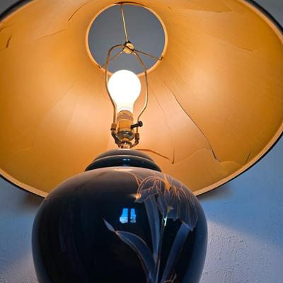 Small natural wood shelf with large ceramic lamp with an iris on it