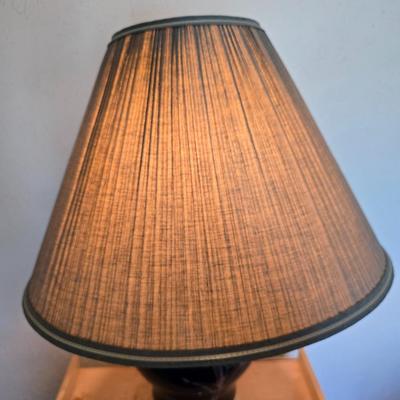 Small natural wood shelf with large ceramic lamp with an iris on it