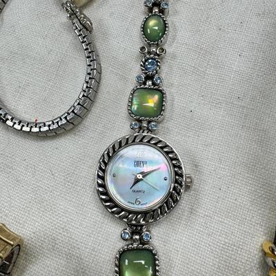 Sale Photo Thumbnail #173: All watches are from one collection, none of them are running assume all need new batteries or maybe other work. 1 Vintage non working pocket watch. Cuff watches, some stones and crystal. Watch bands.