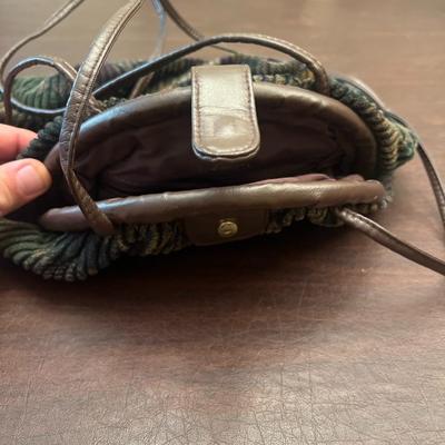 Sale Photo Thumbnail #140: Charming vintage corduroy and brown leather shoulder bag featuring a soft, textured plush corduroy body with an abstract earth-tone pattern. The bag has leather trim, a leather top flap with a snap closure, and a cinched drawstring-style construction. Int