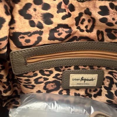 Sale Photo Thumbnail #142: Stylish and roomy Urban Originals fringe tote handbag in olive green faux leather. Features long side fringe accents, dual shoulder straps, and a soft pebbled texture. The interior is fully lined with a bold leopard-print fabric and includes a zippered po