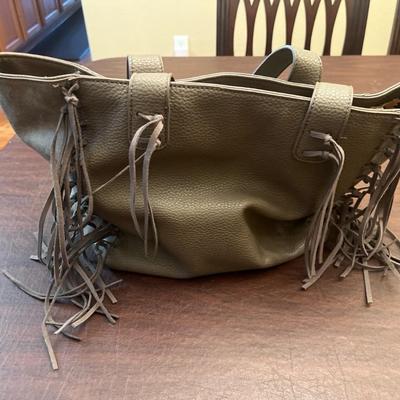 Sale Photo Thumbnail #143: Stylish and roomy Urban Originals fringe tote handbag in olive green faux leather. Features long side fringe accents, dual shoulder straps, and a soft pebbled texture. The interior is fully lined with a bold leopard-print fabric and includes a zippered po