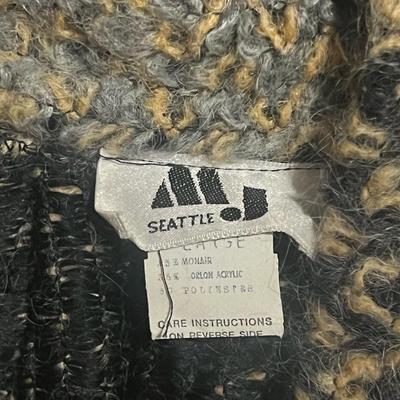 Sale Photo Thumbnail #200: Material: 55% Mohair, 35% Orlon Acrylic, 10% Polyester
Condition: Excellent

Description:
Vintage 1980s long mohair-blend sweater coat from All That Jazz – Seattle. Chunky knit with charcoal, cream, and tan tones, oversized draped front, and knit pocket