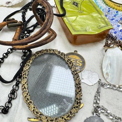 Sale Photo Thumbnail #312: Victorian vanity items, mirror, celluloid brush, shaving brush, early plastic containers. Beads, chains, Jewelry, necklaces, pins, bracelets, there are some strands that might need repair, there is a bag of extra beads, single earrings and of course a bag