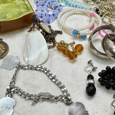 Sale Photo Thumbnail #313: Victorian vanity items, mirror, celluloid brush, shaving brush, early plastic containers. Beads, chains, Jewelry, necklaces, pins, bracelets, there are some strands that might need repair, there is a bag of extra beads, single earrings and of course a bag