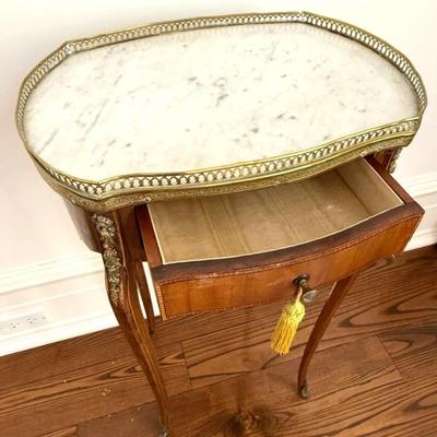 Sale Photo Thumbnail #74: Antique 19th C French Louis XV Style Marble Top Side Table w Brass Gallery, Ormolu Accents and Single Drawer.
Approximate Size: 17" x 12" x 30"

“General marks allover consistent with age and use. Some patina on metal.”