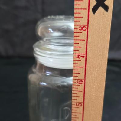 vintage 1981 Planters Mr. Peanut 75th Anniversary glass jar with three square glass apothecary jars, often used as kitchen canisters.