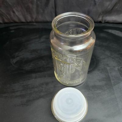 vintage 1981 Planters Mr. Peanut 75th Anniversary glass jar with three square glass apothecary jars, often used as kitchen canisters.