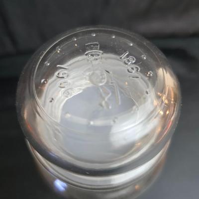 vintage 1981 Planters Mr. Peanut 75th Anniversary glass jar with three square glass apothecary jars, often used as kitchen canisters.