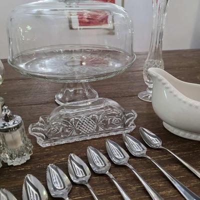 Sale Photo Thumbnail #91: This is a lot including a glass cake stand with dome, glass butter dish, crystal salt and pepper shakers, glass tea pitcher, crystal bud vase, 2 white gravy bowls and 10 grapefruit spoons. These are mostly all unmarked items. You are bidding on the lot me