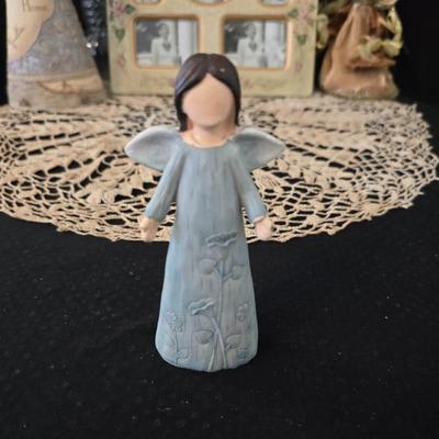 Elegant picture frame with collection of angels, and a large doily