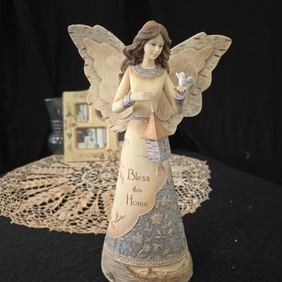 Elegant picture frame with collection of angels, and a large doily