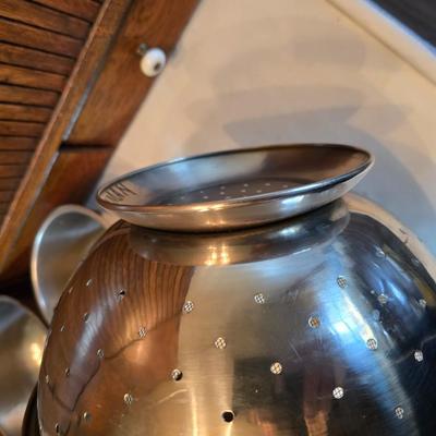 Stainless steel bowls and a strainer with an apron