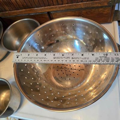 Stainless steel bowls and a strainer with an apron