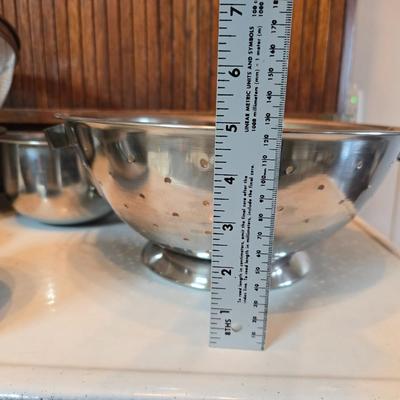 Stainless steel bowls and a strainer with an apron