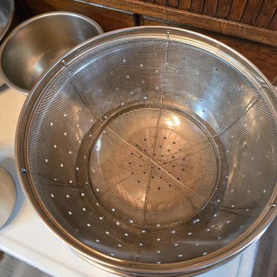 Stainless steel bowls and a strainer with an apron