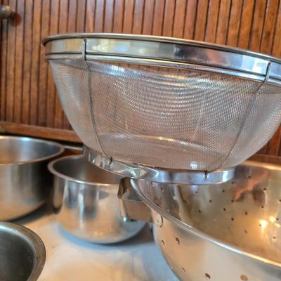 Stainless steel bowls and a strainer with an apron