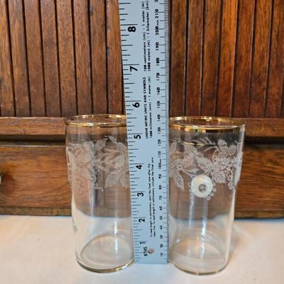 Two glass water pitchers and an assortment of miss-matched drinking glasses