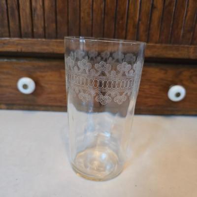 Two glass water pitchers and an assortment of miss-matched drinking glasses