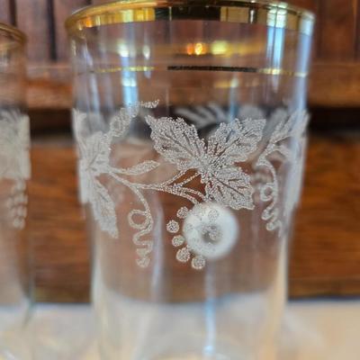 Two glass water pitchers and an assortment of miss-matched drinking glasses