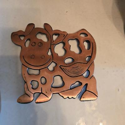 Cow canister - Ceramic cow themed crock - copper-toned cast iron trivet in the shape of a cow - and more