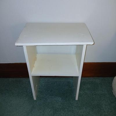 Small white table with a shelf and a wall shelf unit with many cubbies