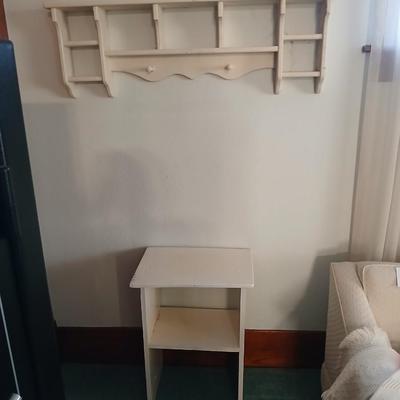Small white table with a shelf and a wall shelf unit with many cubbies