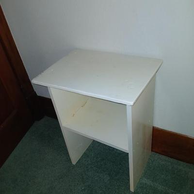 Small white table with a shelf and a wall shelf unit with many cubbies