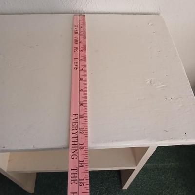 Small white table with a shelf and a wall shelf unit with many cubbies