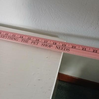 Small white table with a shelf and a wall shelf unit with many cubbies