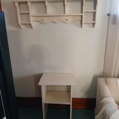 Small white table with a shelf and a wall shelf unit with many cubbies