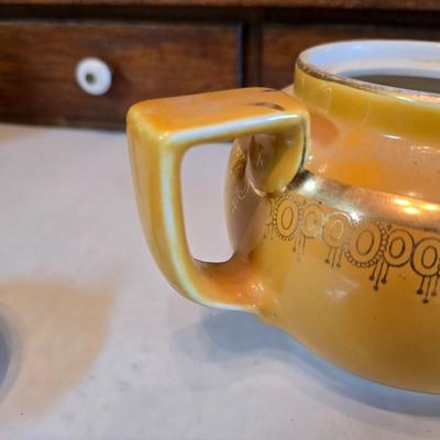 Tea time! Lillian Vernon tea pot - with other tea pots and a set of mid-century demitasse cup and saucer set with a floral pattern.