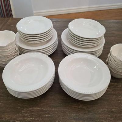 Sale Photo Thumbnail #141: This is a lot including dinner plates and bowls by Pottery Barn, "Emma" pattern with a beaded edge. A few do show signs of wear (light gray lines), but only a few of them. The salad plates and dessert bowls are by Ballard Designs. They are the same white 