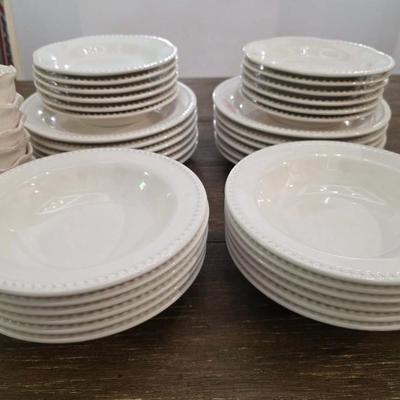 Sale Photo Thumbnail #148: This is a lot including dinner plates and bowls by Pottery Barn, "Emma" pattern with a beaded edge. A few do show signs of wear (light gray lines), but only a few of them. The salad plates and dessert bowls are by Ballard Designs. They are the same white 
